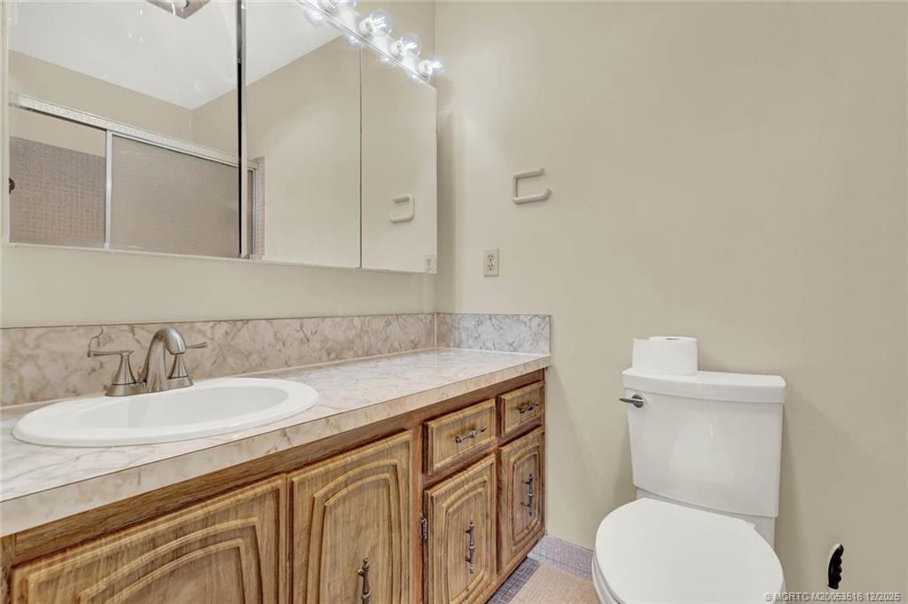 902 Savannas Point Drive, Unit D Fort Pierce, FL 34982 - Photo 24 of 44 a bathroom with a granite countertop toilet sink and mirror