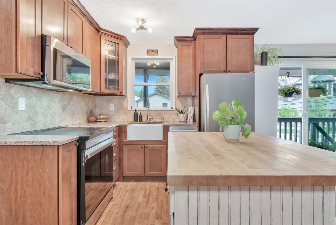 259 6th Street, Unit 8 Steamboat Springs, CO 80487 - Photo 2 of 33 a kitchen with stainless steel appliances granite countertop a sink and a refrigerator
