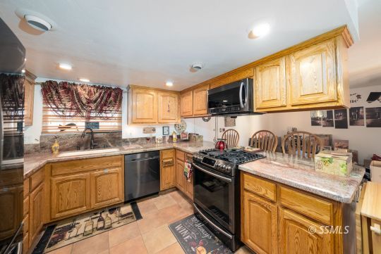 820 West Ward Avenue Ridgecrest, CA 93555 - Photo 8 of 26 a kitchen with granite countertop stainless steel appliances and wooden cabinets