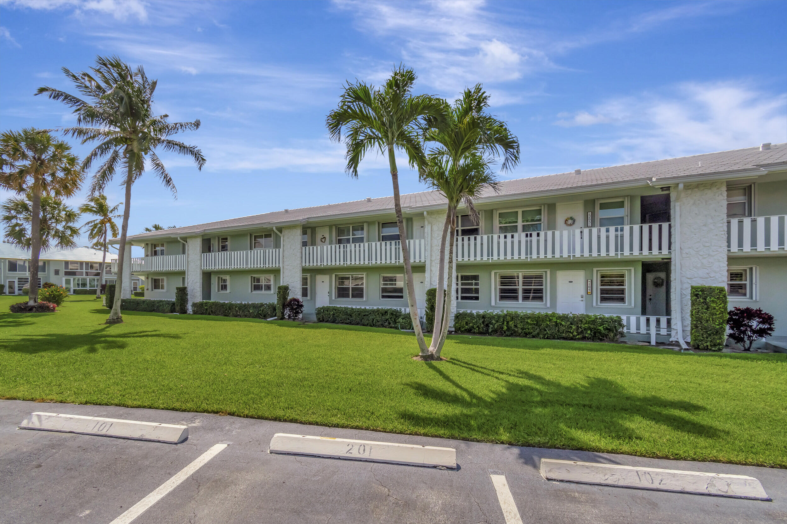 a front view of a house with a garden and trees