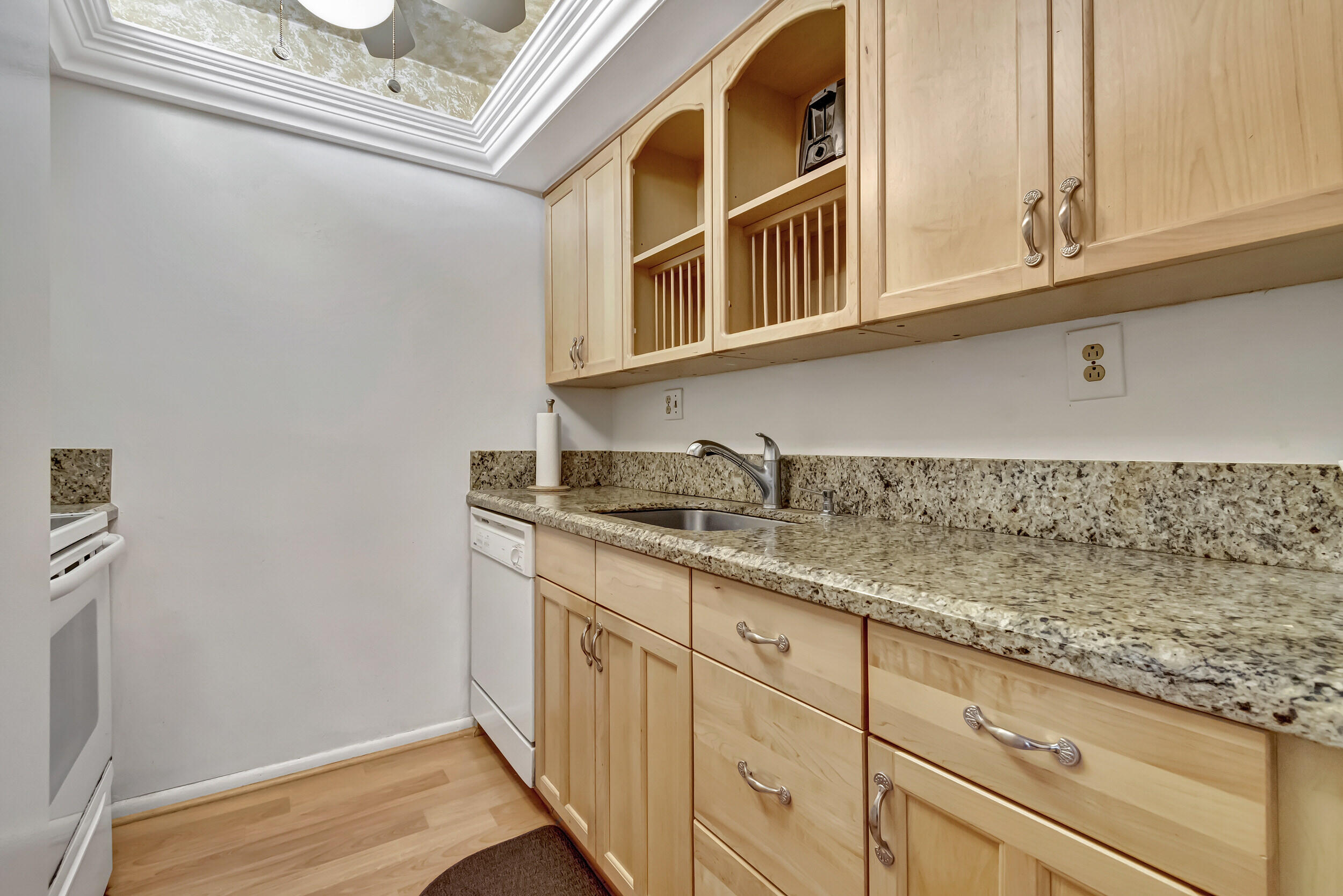 5540 North Ocean Boulevard, Unit 204 Ocean Ridge, FL 33435 - Photo 13 of 52 a kitchen with granite countertop white cabinets and sink