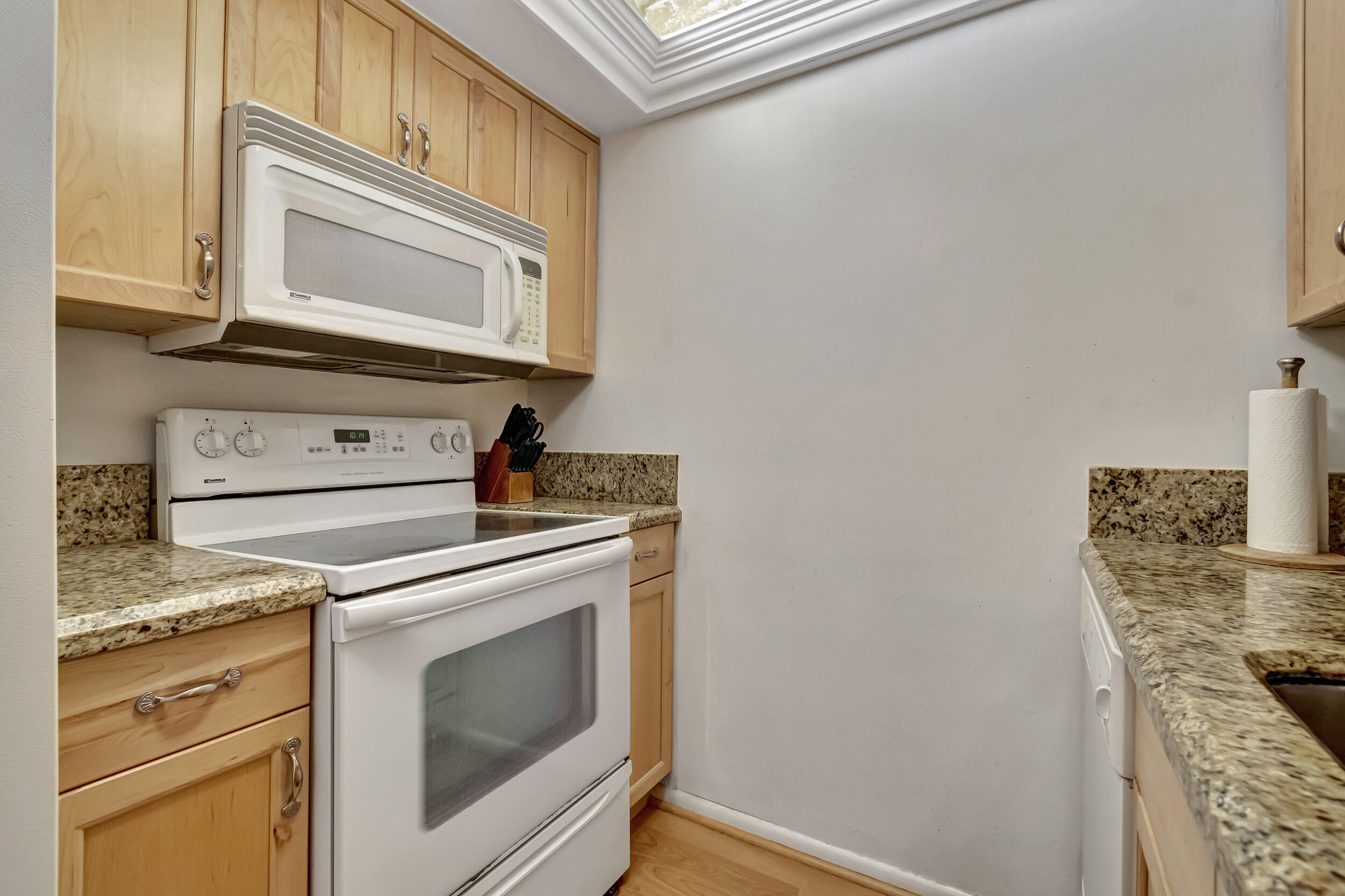 5540 North Ocean Boulevard, Unit 204 Ocean Ridge, FL 33435 - Photo 14 of 52 a kitchen with granite countertop cabinets stainless steel appliances and a sink