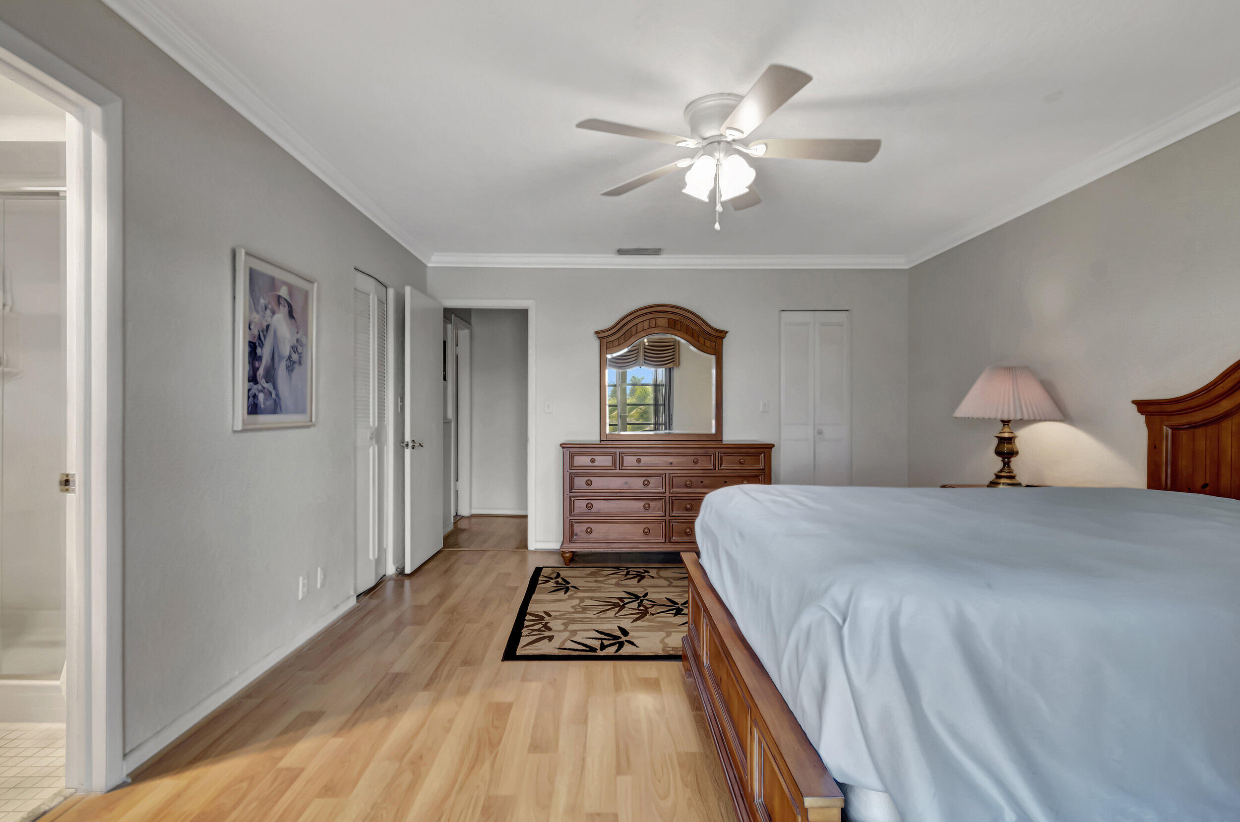 5540 North Ocean Boulevard, Unit 204 Ocean Ridge, FL 33435 - Photo 21 of 52 a bedroom with a large bed and a chandelier