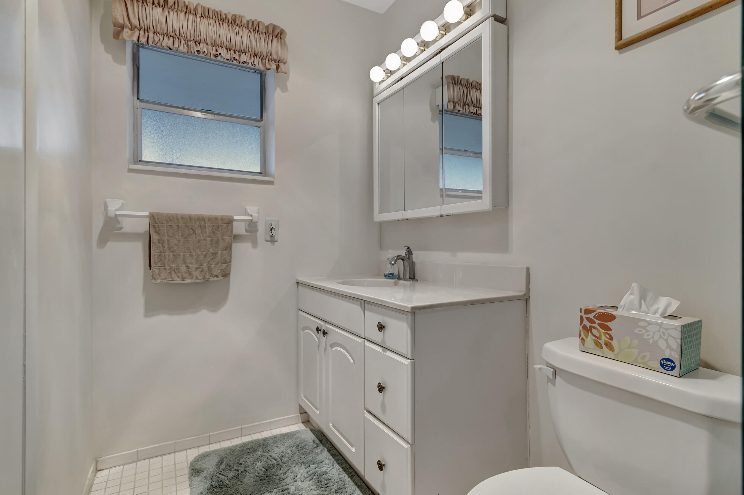 5540 North Ocean Boulevard, Unit 204 Ocean Ridge, FL 33435 - Photo 28 of 52 a spacious bathroom with a toilet sink and mirror