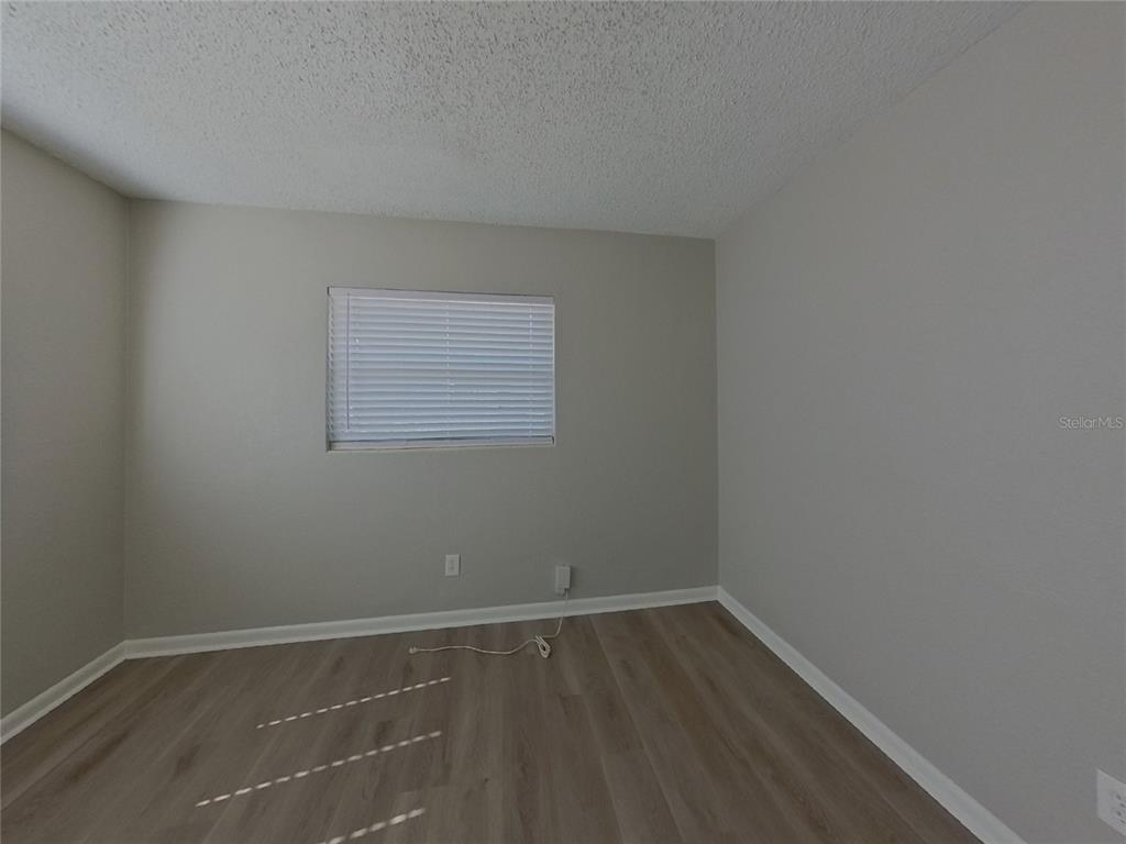 Undisclosed Address Clearwater, FL 33755 - Photo 15 of 22 a view of an empty room with wooden floor and a window