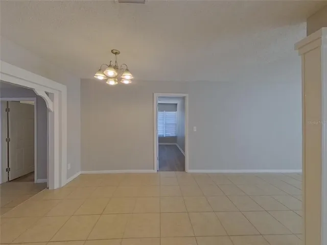 a view of a chandelier in big room and a bathroom