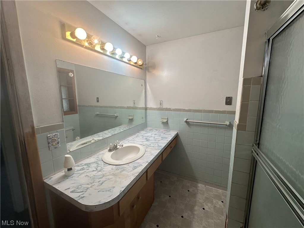 4410 Lane Road Painesville, OH 44077 - Photo 25 of 30 Bathroom with large vanity, tile walls, vinyl flooring, and tasteful backsplash