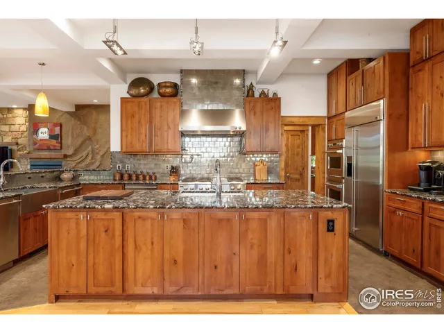 a kitchen with granite countertop a stove refrigerator and cabinets