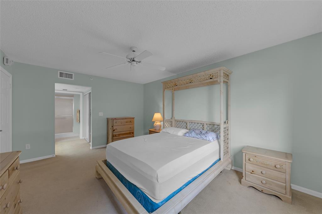 9599 Weldon Circle, Unit 103A Tamarac, FL 33321 - Photo 20 of 26 a bedroom with a bed and a table