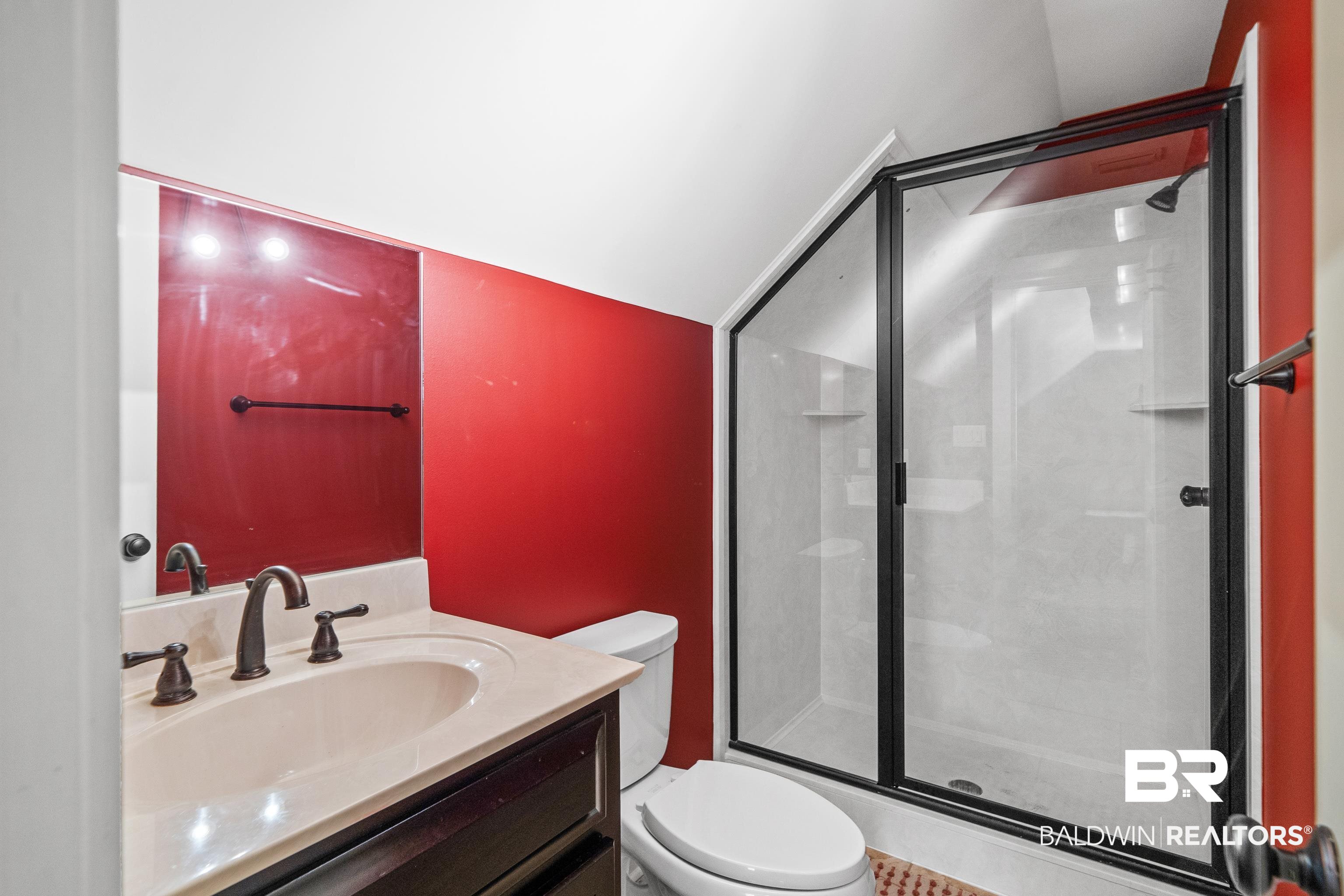 31829 Butler Drive Daphne, AL 36527 - Photo 38 of 48 Bathroom featuring vaulted ceiling, vanity, toilet, and a shower with door