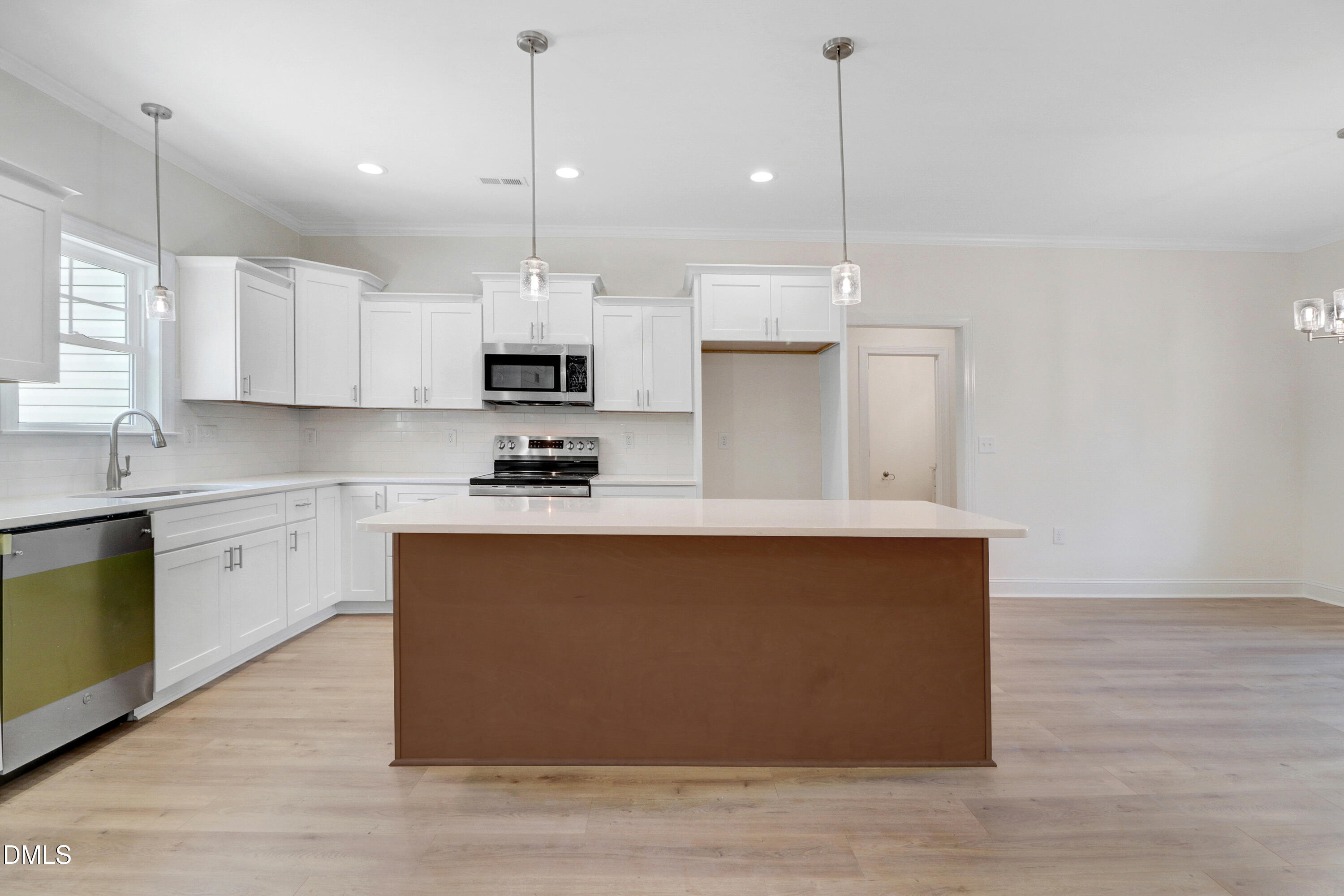 110 Rae Drive Pikeville, NC 27863 - Photo 11 of 35 a kitchen with kitchen island a sink a stove a microwave and wooden floor