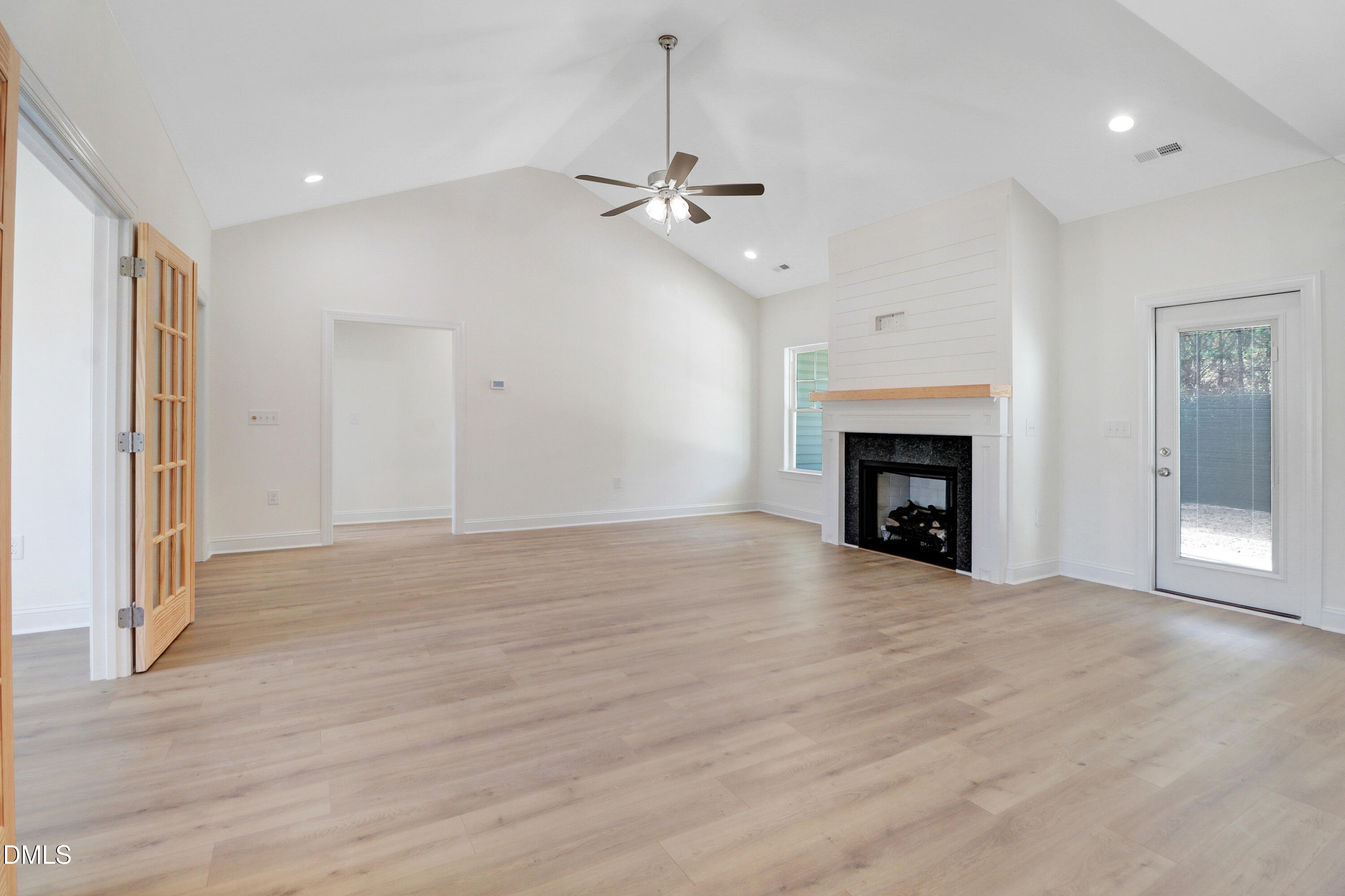110 Rae Drive Pikeville, NC 27863 - Photo 7 of 35 an empty room with wooden floor fireplace and windows