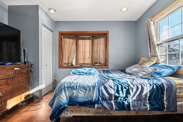 a bedroom with a bed and large windows