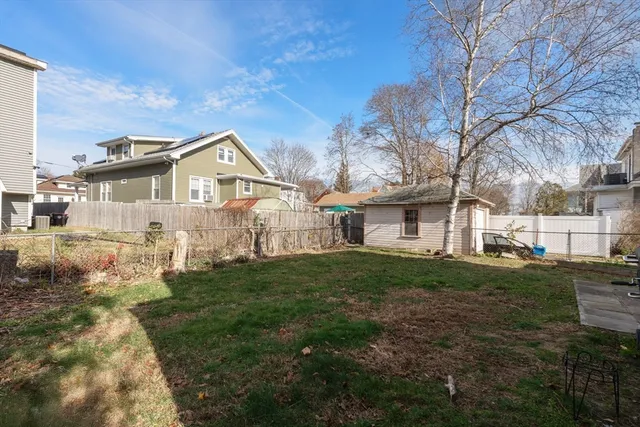 a view of a yard in front of a house with large trees