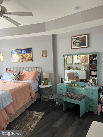 a bedroom with a bed and a large mirror with a dresser