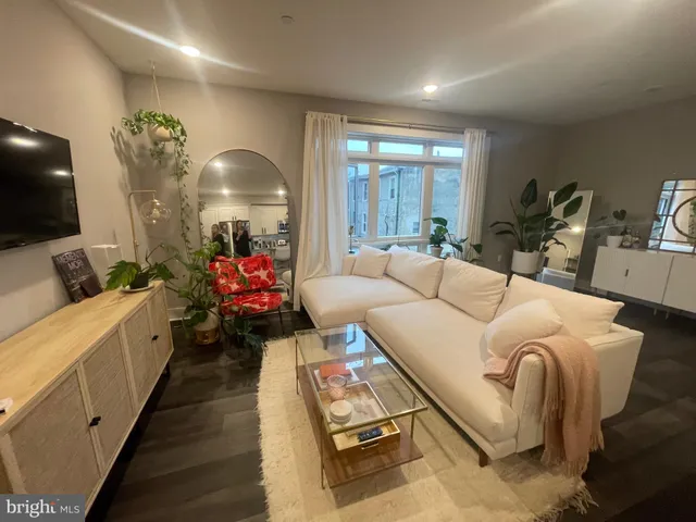 a living room with furniture a chandelier and a flat screen tv