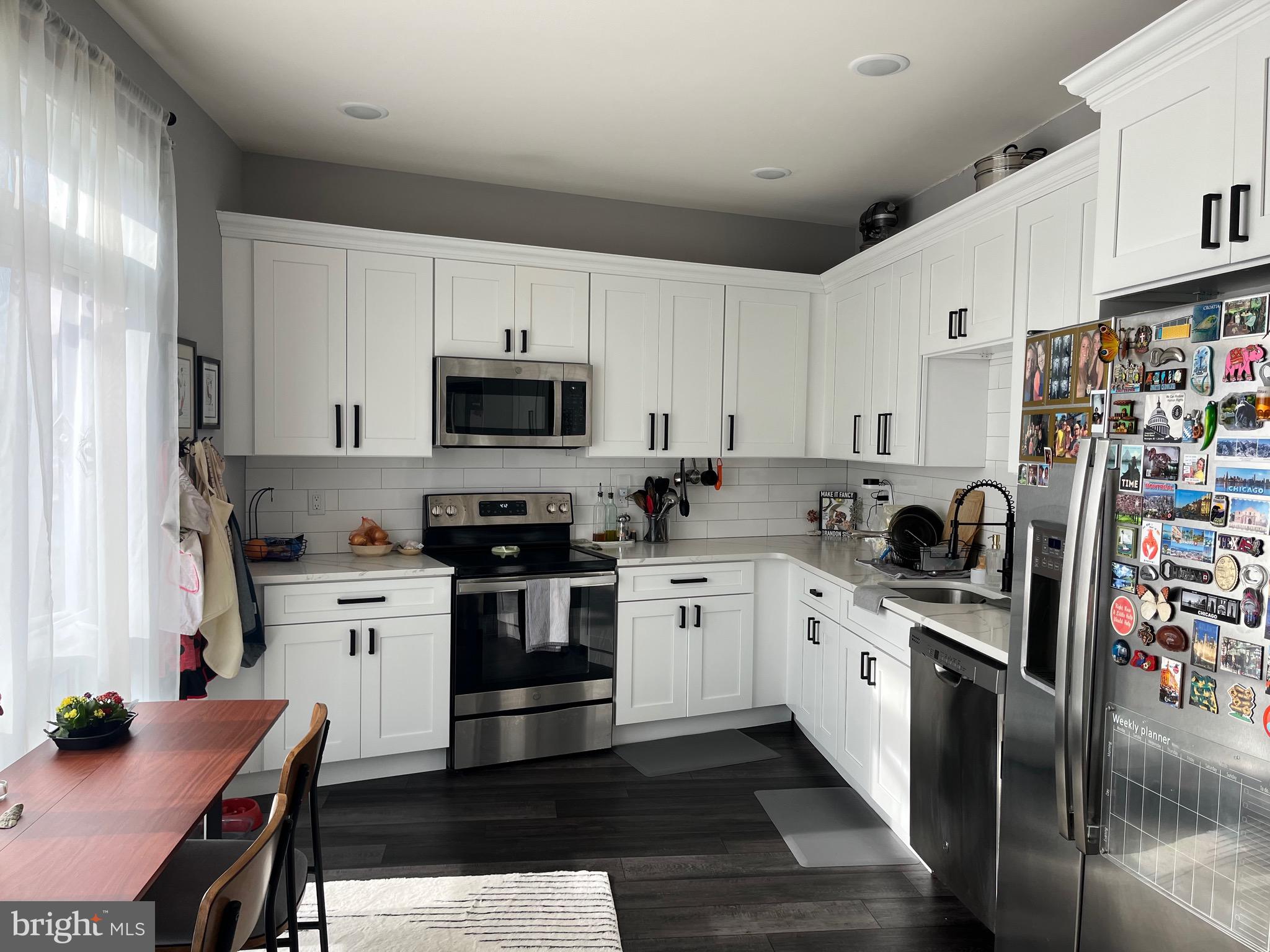 4001 Ridge Avenue Philadelphia, PA 19129 - Photo 9 of 26 a kitchen with stainless steel appliances granite countertop a stove top oven a sink dishwasher and white cabinets with wooden floor