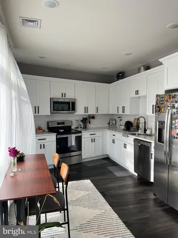 a living room with furniture a large window and a dining table
