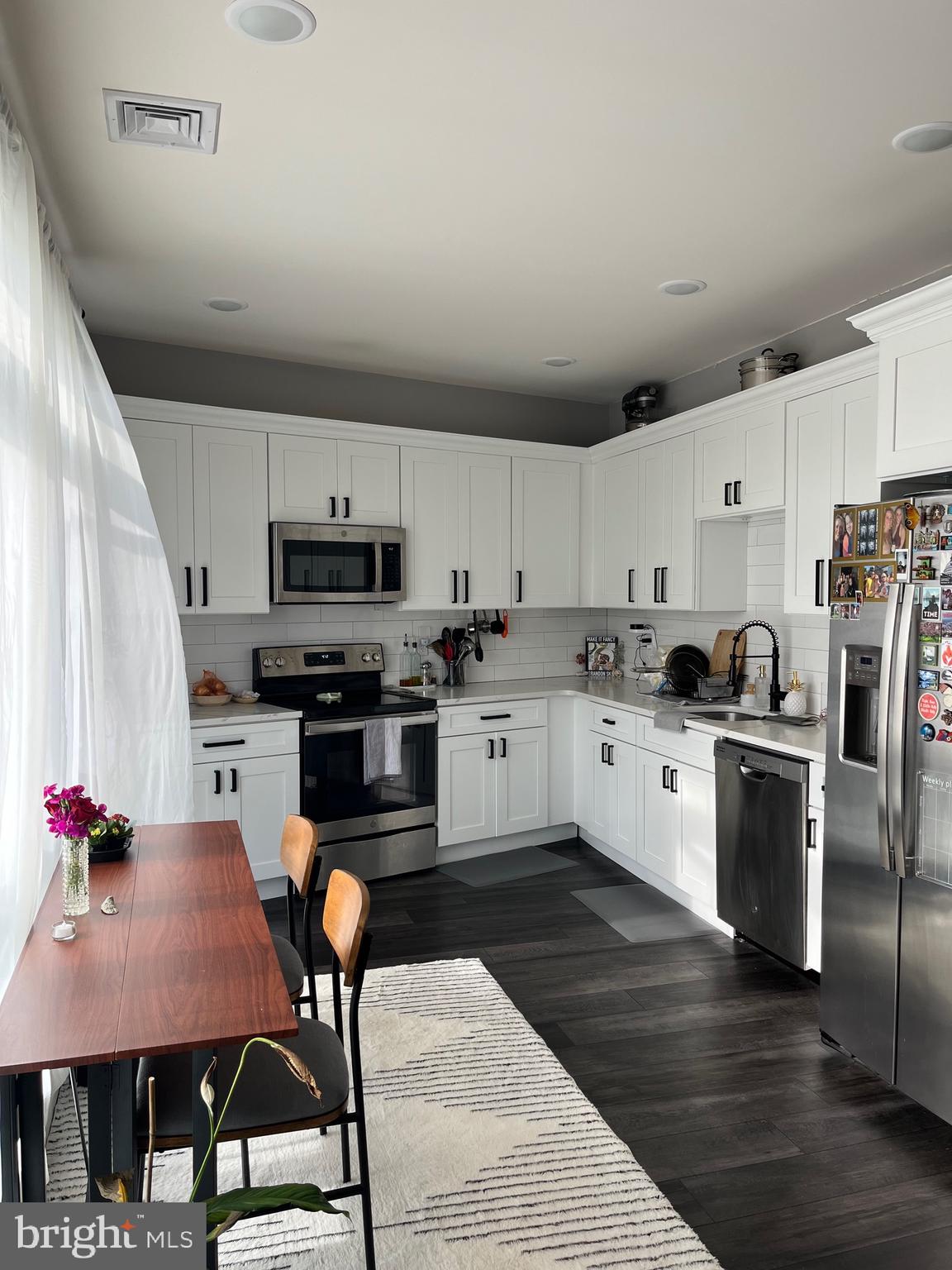 4001 Ridge Avenue Philadelphia, PA 19129 - Photo 10 of 26 a kitchen with granite countertop a sink stainless steel appliances and white cabinets