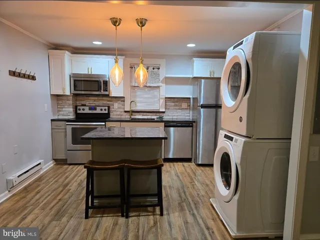 a kitchen with kitchen island a sink a stove a microwave and a refrigerator
