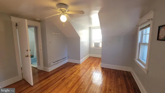 a view of a livingroom with wooden floor and a ceiling fan