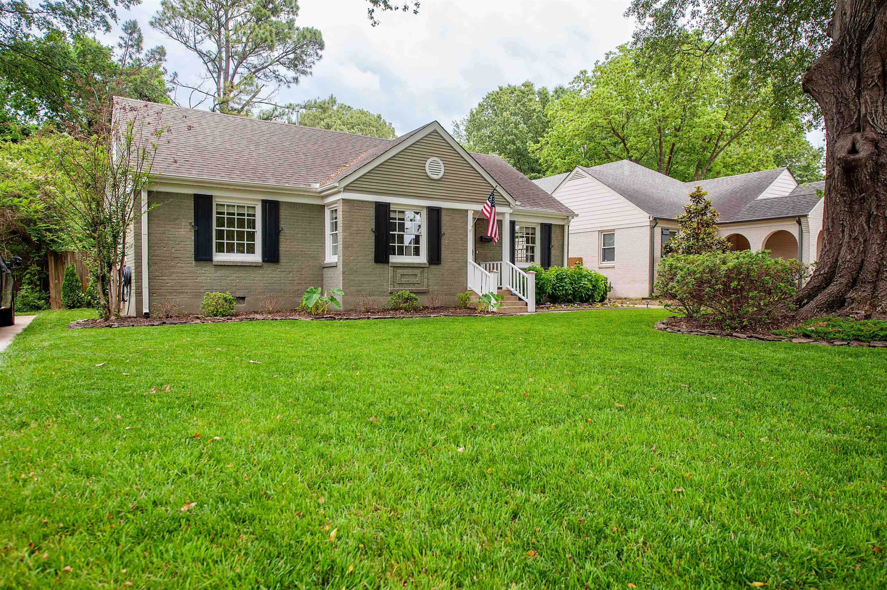 a front view of a house with a yard and trees