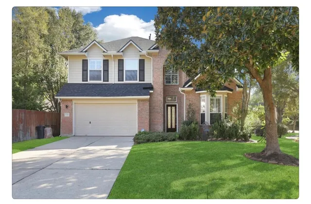 a front view of a house with a garden and trees