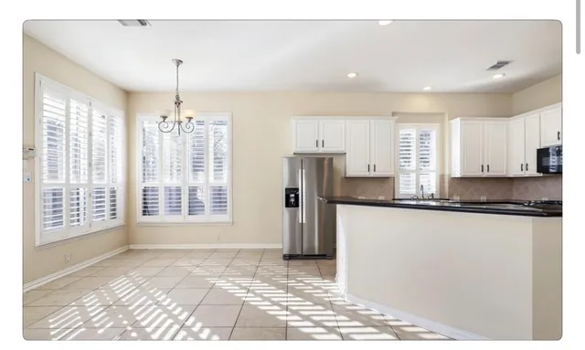 a kitchen with stainless steel appliances granite countertop a refrigerator a sink a stove a microwave and island