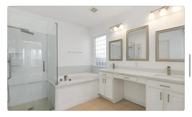 a bathroom with a sink double vanity granite tub shower and a mirror