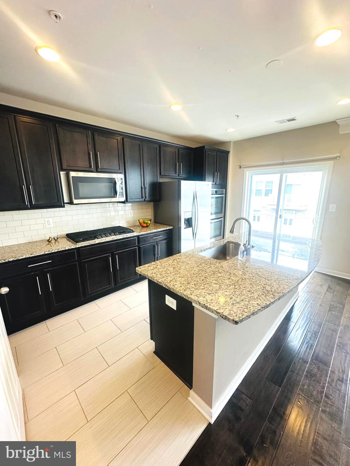 25576 Tolar Square Chantilly, VA 20152 - Photo 6 of 55 a kitchen with stainless steel appliances granite countertop a sink counter space and cabinets