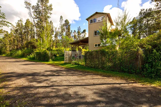 a front view of a house with a yard and trees