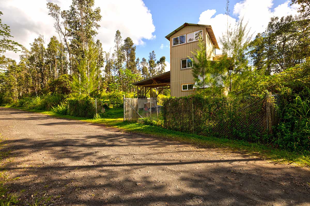 a front view of a house with a yard and trees