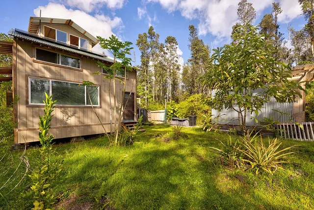 a view of a house with backyard and sitting area