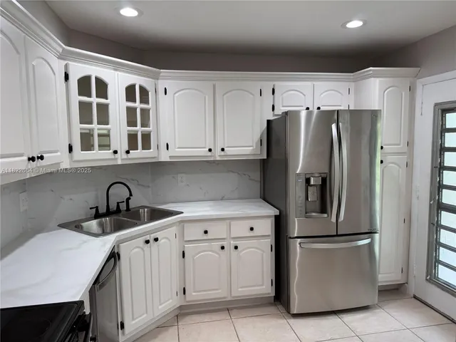 a kitchen with stainless steel appliances granite countertop a refrigerator and a sink
