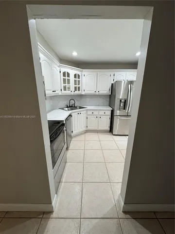 a kitchen with a sink a stove and cabinets