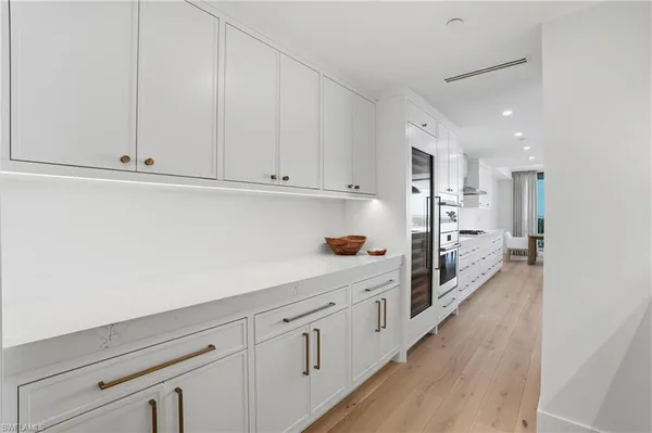 a kitchen with white cabinets and refrigerator