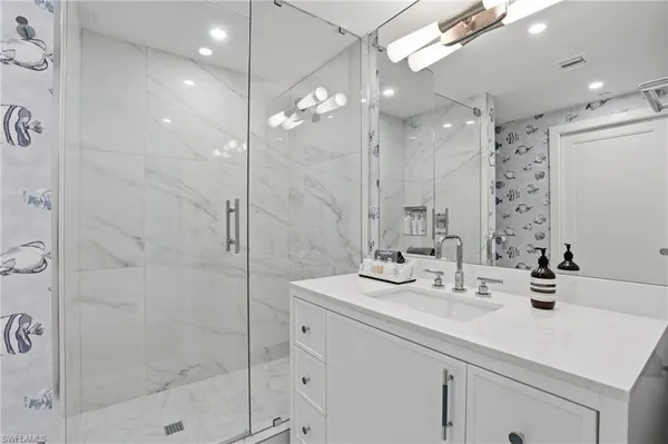 a bathroom with a sink shower and a mirror