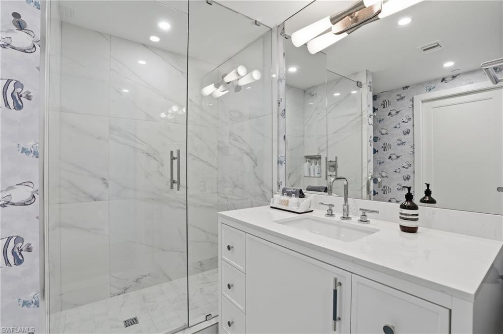 13945 Old Coast Road, Unit 803 Naples, FL 34110 - Photo 19 of 37 a bathroom with a sink shower and a mirror