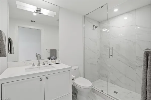 a bathroom with a sink toilet a mirror and shower