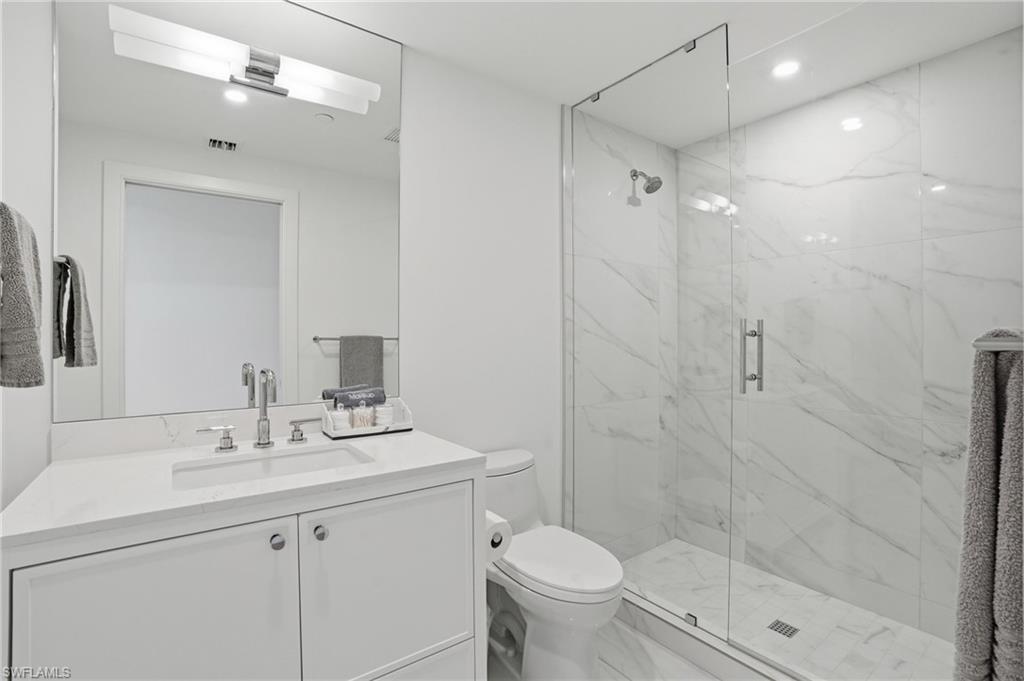13945 Old Coast Road, Unit 803 Naples, FL 34110 - Photo 21 of 37 a bathroom with a sink toilet a mirror and shower