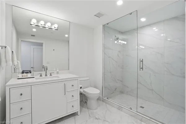 a bathroom with a double vanity sink mirror and toilet