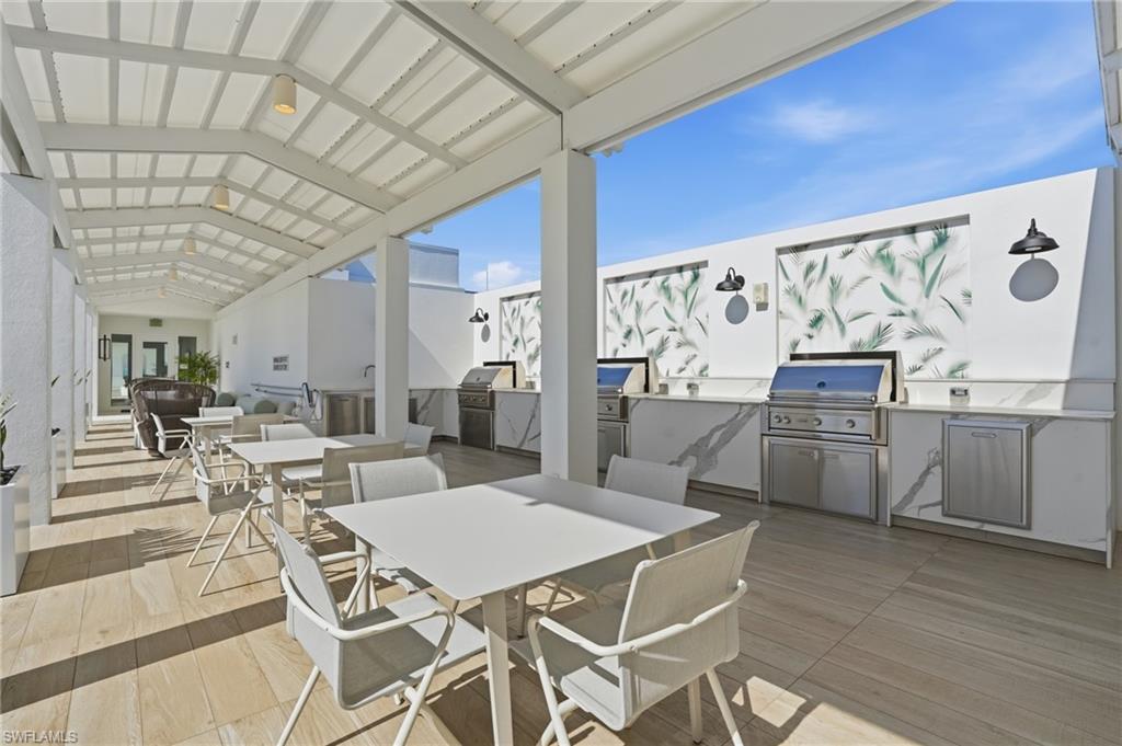 13945 Old Coast Road, Unit 803 Naples, FL 34110 - Photo 31 of 37 a view of a dining room with furniture and wooden floor