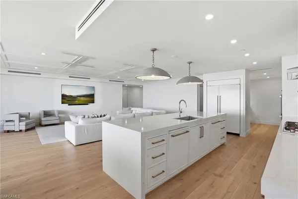 a large kitchen with stainless steel appliances kitchen island granite countertop a lot of counter space and wooden floors