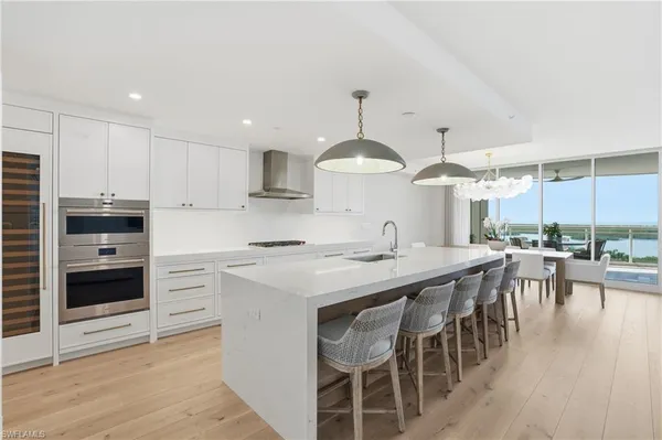 a kitchen with stainless steel appliances a stove a sink a center island and cabinets