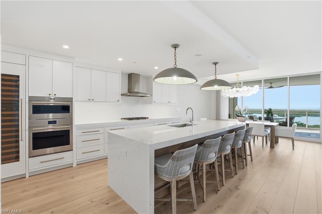 13945 Old Coast Road, Unit 803 Naples, FL 34110 - Photo 9 of 37 a kitchen with stainless steel appliances a stove a sink a center island and cabinets