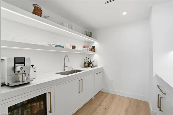 a kitchen with a sink cabinets and wooden floor