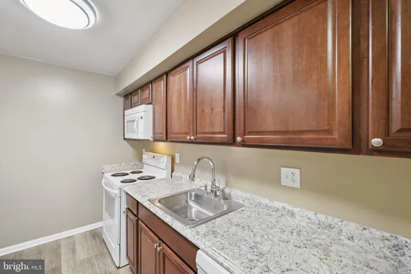 a kitchen with granite countertop stainless steel appliances a sink and cabinets
