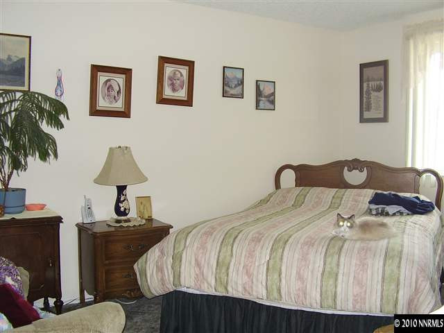3415 Canvasback Lane Reno, NV 89508 - Photo 2 of 3 a bedroom with a bed and a lamp on table