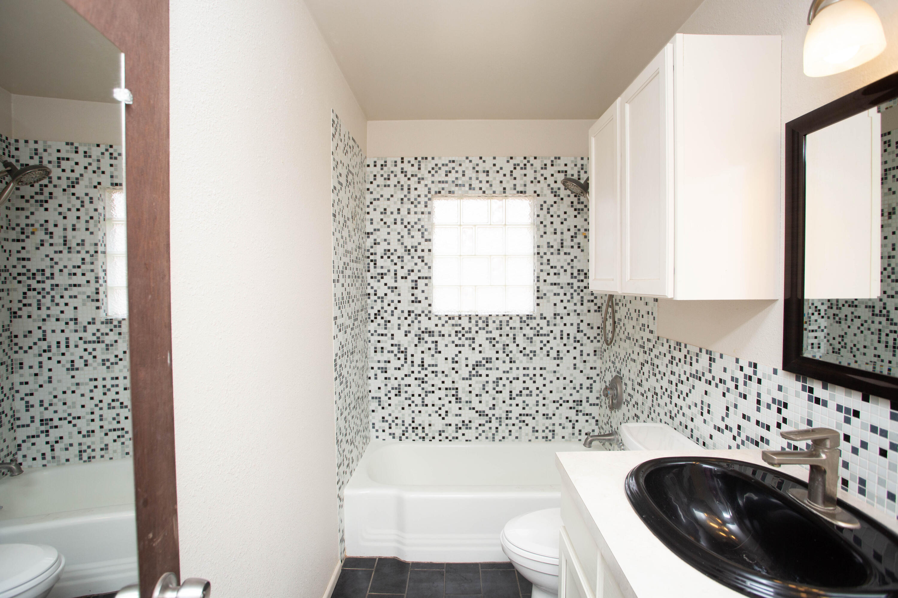 4932 9th Street Lubbock, TX 79416 - Photo 14 of 29 a bathroom with a sink a bathtub and next to a window