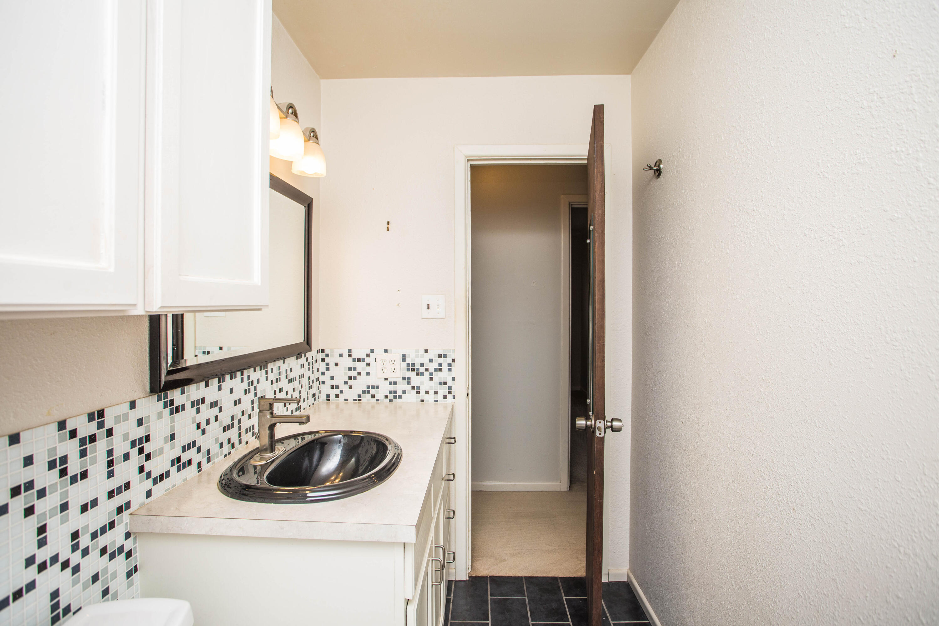 4932 9th Street Lubbock, TX 79416 - Photo 16 of 29 a bathroom with a sink and a mirror